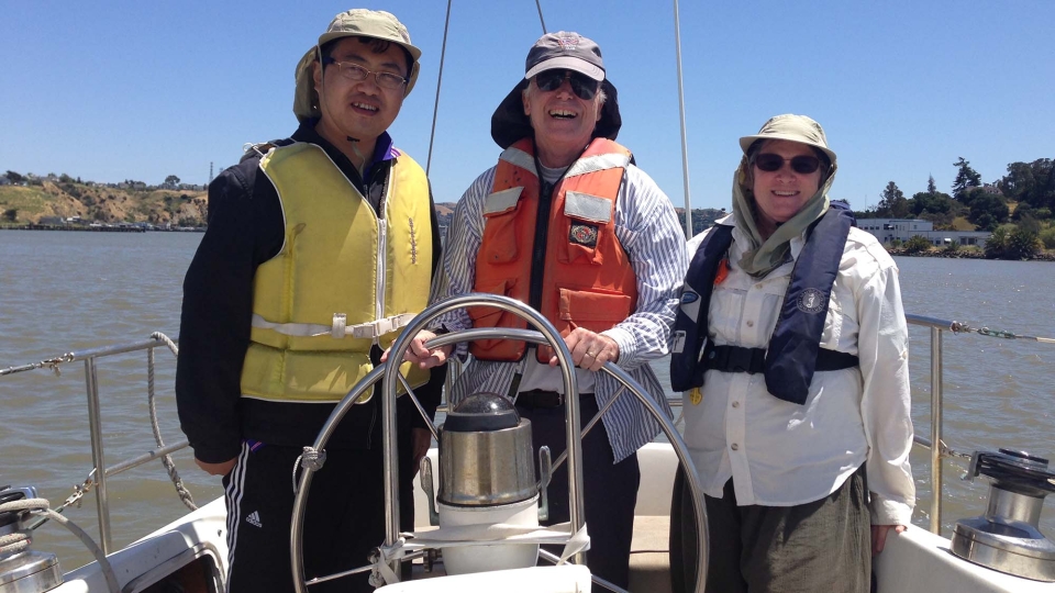 Jay Lund and Jean Lund on sailboat with another person.